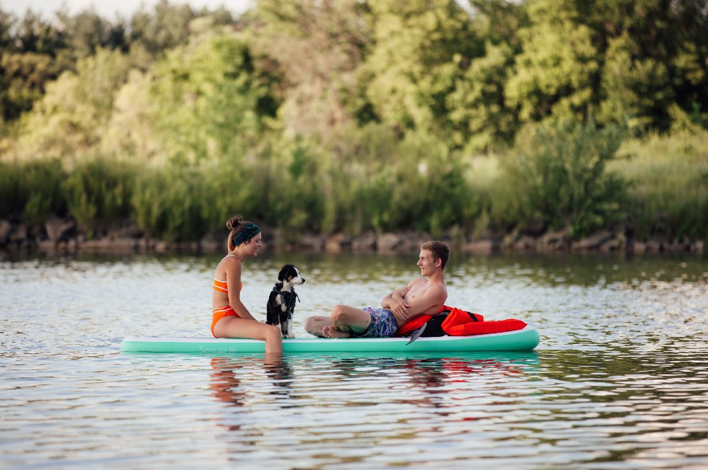 young couple with dog on paddleboard