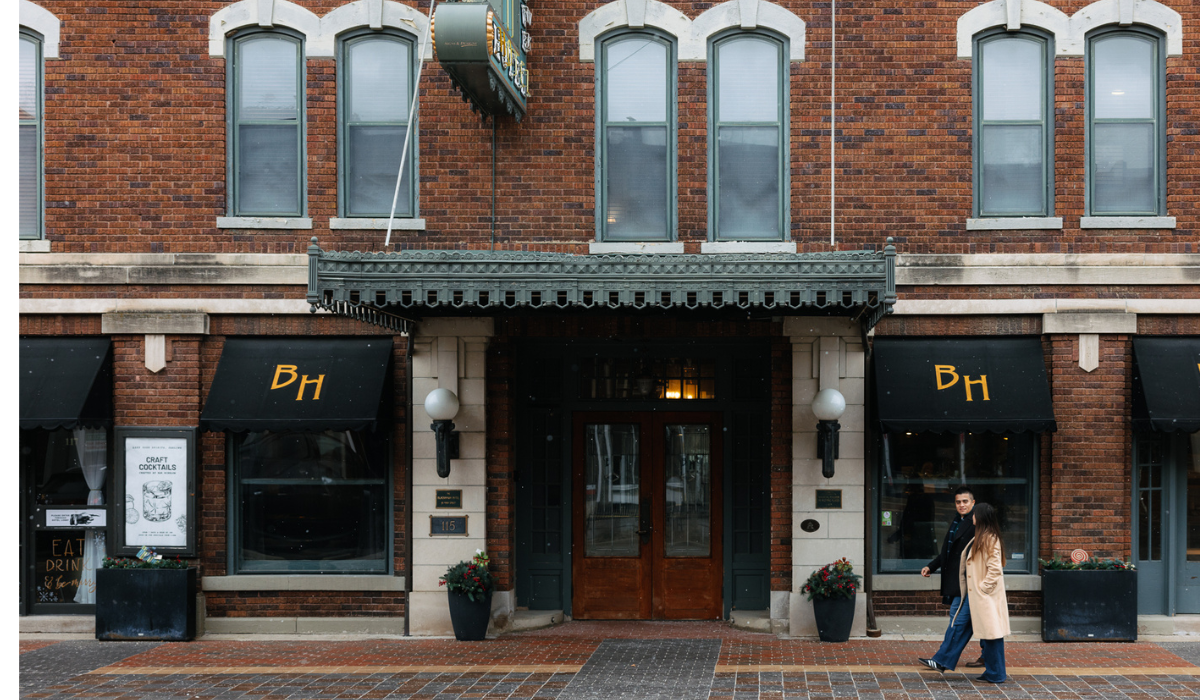 couple walking in front of historic hotel