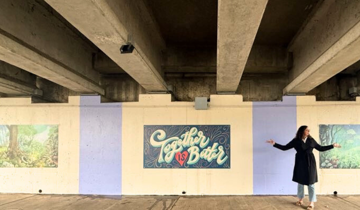 woman standing in front of murals 