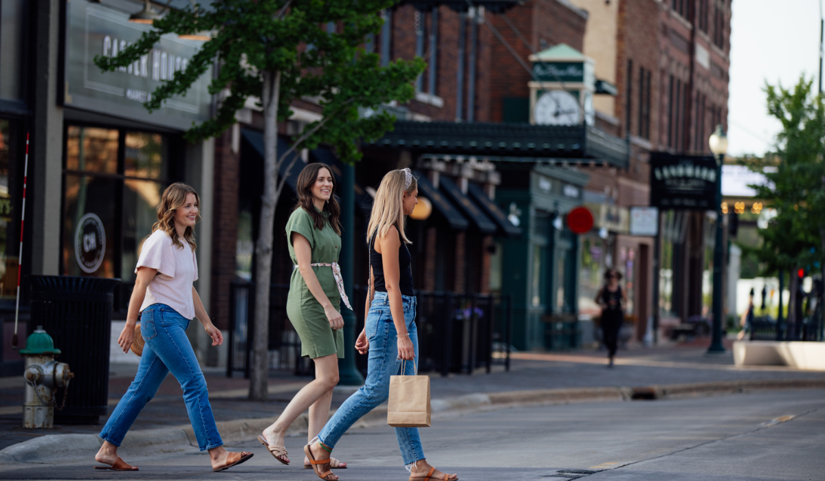 three women walking in a historic downtown with shopping bags