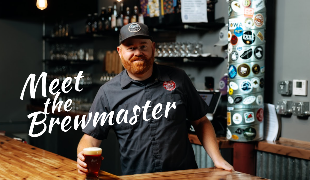 man standing behind the bar with a glass of beer
