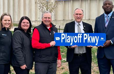 Officials with Playoff Parkway Sign